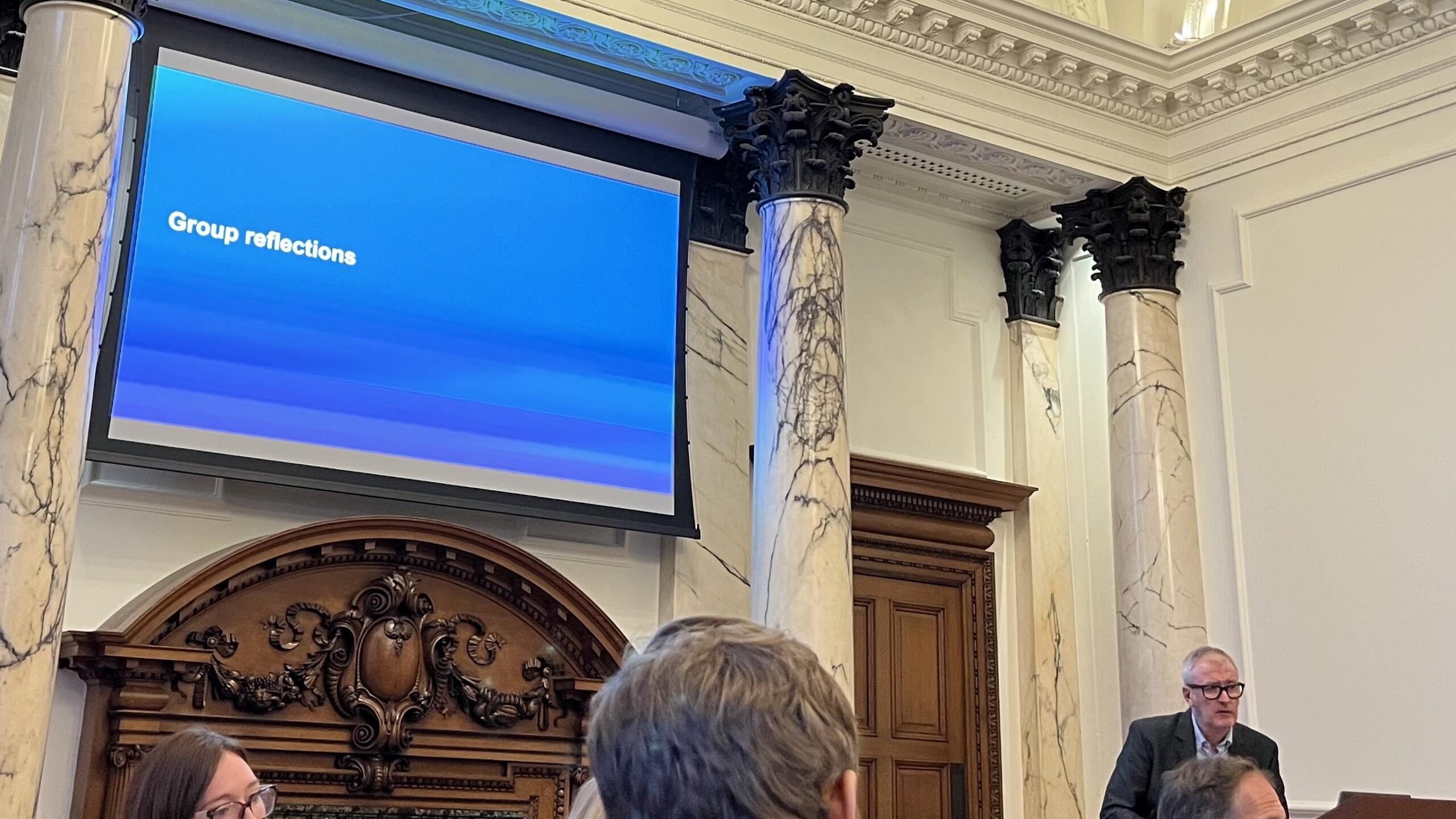 Photograph of a projector screen at a roundtable event